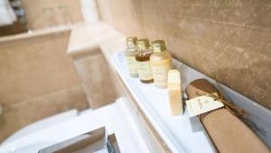 three bottles of essential oils sitting on a bath tub at Derby Manor in Bournemouth
