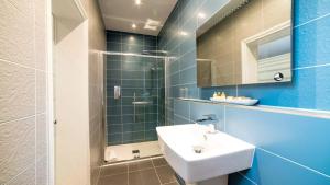 a bathroom with a sink and a mirror at Derby Manor in Bournemouth