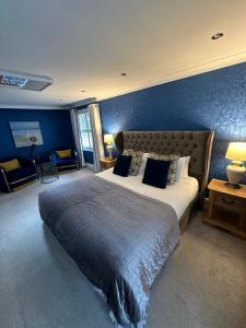 a bedroom with a large bed with a blue wall at Derby Manor in Bournemouth