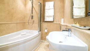a bathroom with a tub and a sink and a toilet at Derby Manor in Bournemouth