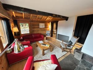 a living room with a red couch and a table at Chalet traditionnel Haute Nendaz in Nendaz