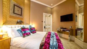 a bedroom with a large white bed with colorful pillows at Derby Manor in Bournemouth