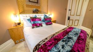 a bedroom with a large white bed with pillows at Derby Manor in Bournemouth