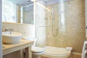 a bathroom with a sink toilet and a shower at Derby Manor in Bournemouth