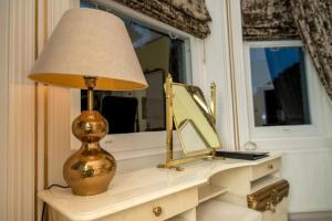 a lamp sitting on a desk with a mirror at Derby Manor in Bournemouth