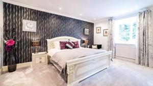 a bedroom with a white bed and a black and white wallpaper at Derby Manor in Bournemouth
