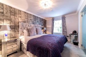 a bedroom with a large bed with a stone wall at Derby Manor in Bournemouth