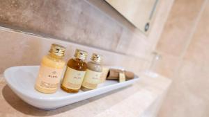 two bottles of essential oils on a shelf in a bathroom at Derby Manor in Bournemouth