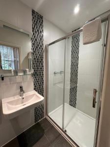 a bathroom with a shower and a sink and a shower at Derby Manor in Bournemouth