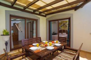 jadalnia z drewnianym stołem i krzesłami w obiekcie Villa Maca by Villa Plus w Corralejo