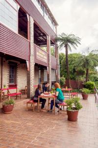 three people sitting at a table outside of a building at Katoomba Mountain Lodge in Katoomba