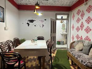 a dining room with a table and chairs and a couch at Holidays homestay in Mirik