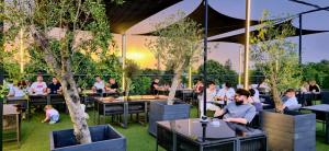 a restaurant with people sitting at tables with trees at Hotel Premier Botosani in Botoşani