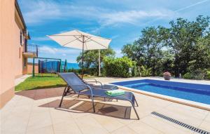 a chair with an umbrella next to a swimming pool at Holiday Home Barisici V in Šumber