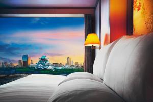 a bedroom with a window with a view of a city at Hotel New Otani Osaka in Osaka