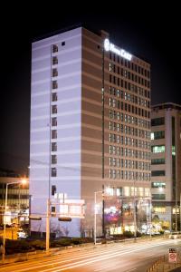 un bâtiment éclairé dans une rue de la ville la nuit dans l'établissement Hotel L'art Gimpo, à Gimpo