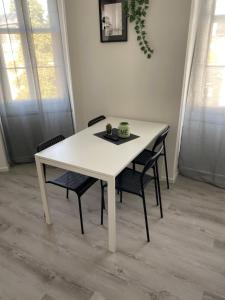 a white table and chairs in a room at Greenhome Lörrach -Ihre Apartments im 3-Ländereck- in Lörrach