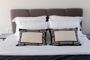 ein Bett mit schwarzen und weißen Kissen darauf in der Unterkunft Villa Koko Vinišće with heated pool and sea view in Vinišće + 13 Fotos