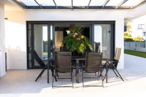 eine Glaserweiterung eines Hauses mit einem Tisch und Stühlen in der Unterkunft Villa Koko Vinišće with heated pool and sea view in Vinišće