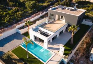 eine Luftaufnahme eines Hauses mit Swimmingpool in der Unterkunft Villa Koko Vinišće with heated pool and sea view in Vinišće