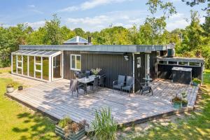 a house with a deck with a table and chairs at Awesome Home In Knebel With 2 Bedrooms And Internet in Ebeltoft +16 photos
