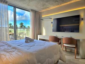 a hotel room with a bed and a desk and a television at Yacht by Hosppedar in João Pessoa +114 photos