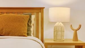 a bedroom with a bed and a lamp on a table at Whale Song - Absolute Beachfront in New Brighton