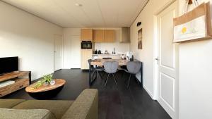 Una cocina y una sala de estar con mesa y sillas. en Duindroom by Droomvilla, en Schoorl