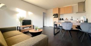 Una sala de estar con un sofá y una cocina. en Duindroom by Droomvilla, en Schoorl 17 fotos más