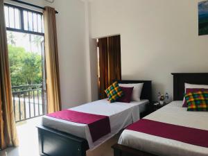 Postel nebo postele na pokoji v ubytování Sri White Villa Airport Boutique Hotel