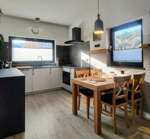 a kitchen with a table and chairs in a room at APART 558 Szczyrk, Ski&Bike, basen, blisko wyciągów i szlaków in Szczyrk