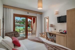a hotel room with a bed and a desk with a television at Hotel Mariposas in Villasimius