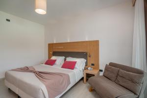 a bedroom with a large bed and a couch at Hotel Mariposas in Villasimius