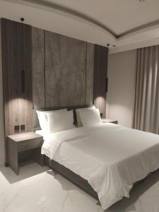a bedroom with a large bed with white sheets and pillows at شقق ثري ستار للشقق المخدومة in Riyadh