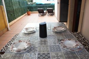 a table with plates and chargers on a patio at Apartamento Noja Playa Trengandin in Noja