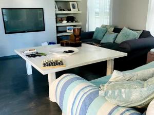 Una mesa de centro blanca en una sala de estar con un sofá en Beach House on 5th Hermanus, en Hermanus