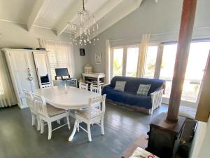 una sala de estar con una mesa y un sofá en Beach House on 5th Hermanus, en Hermanus