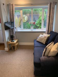 a living room with a blue couch and a window at The Hideaway in Hockering