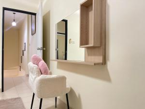 a bathroom with two pink chairs and a mirror at Baan Mali Three in Hua Hin