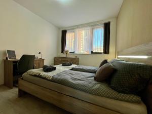 ein Schlafzimmer mit einem Bett mit Schreibtisch und einem Fenster in der Unterkunft City Centre Simonffy Apartment in Debrecen
