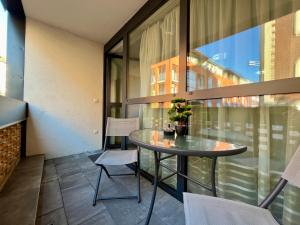 ein Balkon mit Glastisch und Stühlen in der Unterkunft City Centre Simonffy Apartment in Debrecen