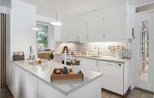 a kitchen with white cabinets and a counter top at Holiday Home Sandtoftevej Blåvand Ix in Blåvand