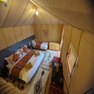 Postel nebo postele na pokoji v ubytování Erg Chebbi Romantic Desert Camp