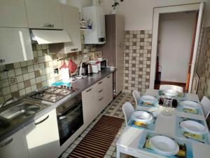 a kitchen with a sink and a table with chairs at Moderno appartamento sulle Rive in Trieste +11 photos