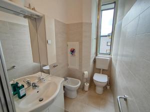 a white bathroom with a sink and a toilet at Moderno appartamento sulle Rive in Trieste