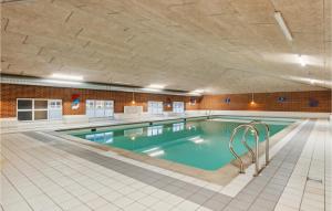 a large swimming pool in a building with a tile floor at Lejlighed 190 in Rømø