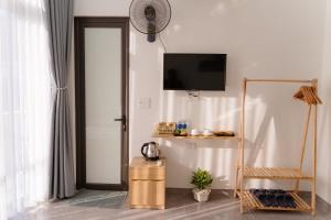 a living room with a television and a door at Apollo Hotel in Dồng Văn