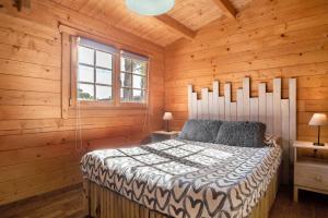 Un dormitorio con una cama en una cabaña de madera. en La Cabaña en Vejer, en Vejer de la Frontera 18 fotos más