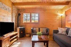 Una sala de estar con un sofá y un televisor. en La Cabaña en Vejer, en Vejer de la Frontera