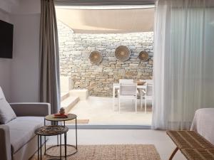 a living room with a couch and a stone wall at Mando Seaside Villa in Naousa